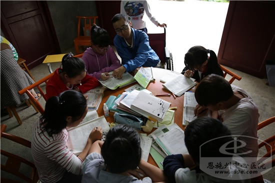 谭海波正在给孩子们辅导暑假作业