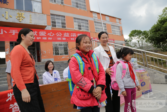 爱心团队负责人为同学们献上书包