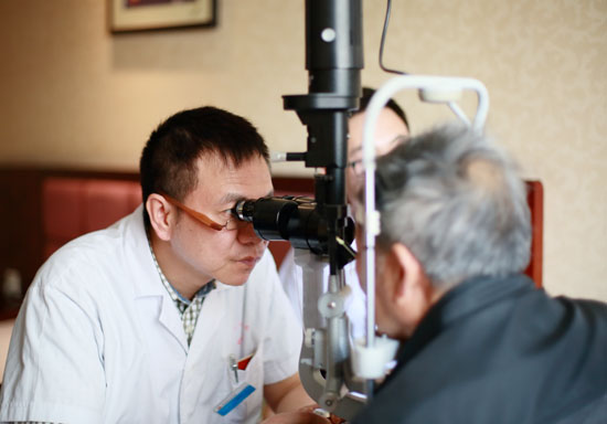 眼科中心主任李家璋为福利院老人检查眼睛