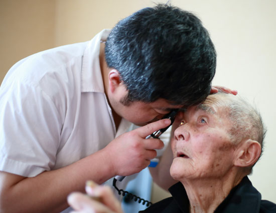 眼科中心副主任吴青松为福利院老人检查眼睛