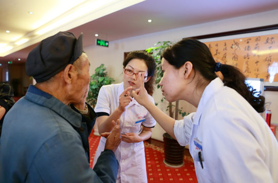 医护人员仔细询问老人眼疾情况
