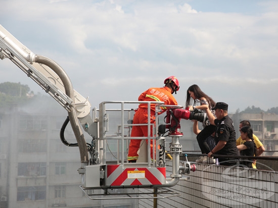 被困人员搭乘云梯安全离开火场