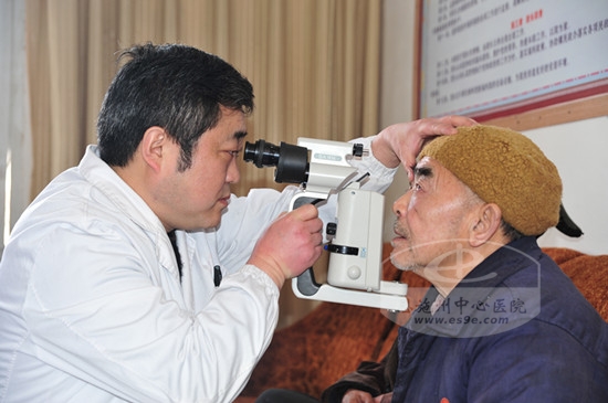 眼科中心副主任吴青松为符合手术条件的老人进行再次检查