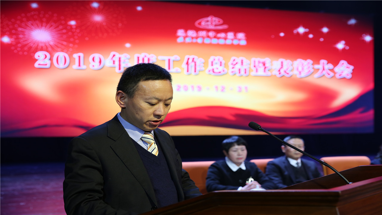 州中心医院党委委员、总会计师梁秀林同志宣读“州中心医政〔2019〕77号”文件《关于授予孙国珍等19位专家2019年度“夕阳红”奉献奖的决定》